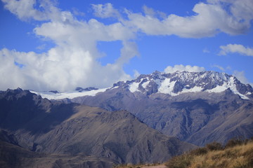 Brown and white mountain under a cloudy blue sky