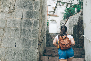 woman climbing up by city stair in perast, montenegro