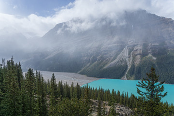 Aerial view of wonderfully blue Lake Peyto on a moody autumn day with clouds and sun and snow in...