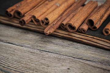 Cinnamon sticks on wooden background.