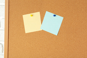 Sticky notes with pushpins and blank space on cork background. School or business concept
