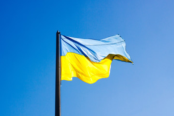 Ukrainian country flag on blue sky background. Sunny.