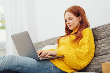 Young woman relaxing at home with a laptop