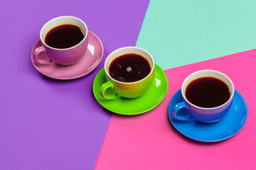 Colorful coffee cups and saucers on colorful vibrant background