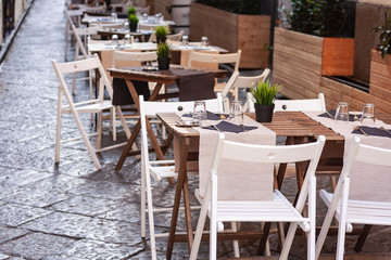 Fototapeta na wymiar Tables with chairs on the terrace in a café in Catania, Sicily, Italy