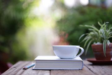 White cup with plant and notebooks