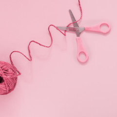 Rosy scissors cut pink thread, pastel background, minimal, art, flatlay Concept - a break between actions, stop