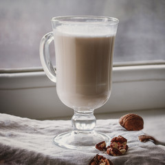 Walnut milk on a beige background, alternative drink, close-up