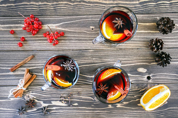 Mulled wine with spices on wooden rustic background, top view.
