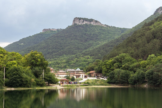 Houses stand on the lake between the mountains