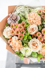 beautiful spring bouquet. flowers arrangement with various of colors in glass vase on old table. bright room