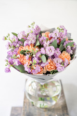 beautiful spring bouquet. flowers arrangement with various of colors in glass vase on old table. bright room