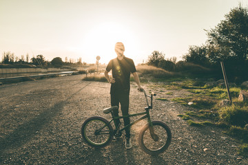 Bmx bike rider in a sunset. Guy riding a bmx bike