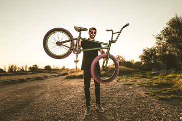 Fototapeta na wymiar Bmx bike rider in a sunset. Guy riding a bmx bike