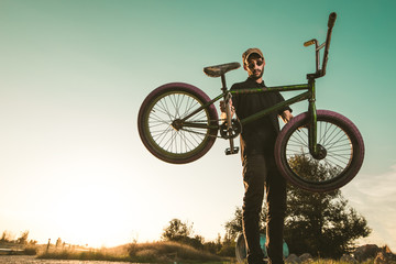 Bmx bike rider in a sunset. Guy riding a bmx bike