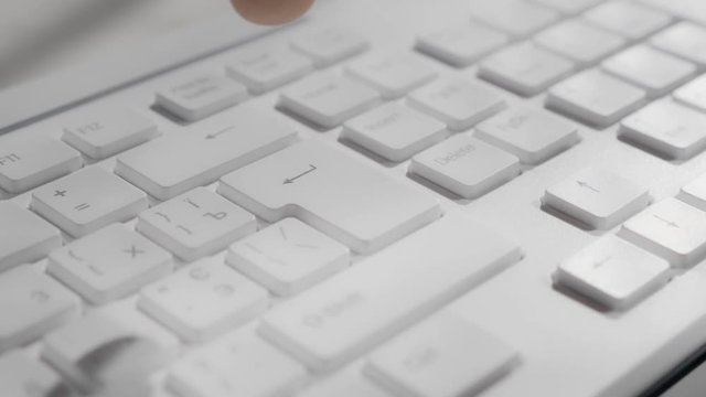 Pressing the enter key on a computer keyboard. Close-up footage