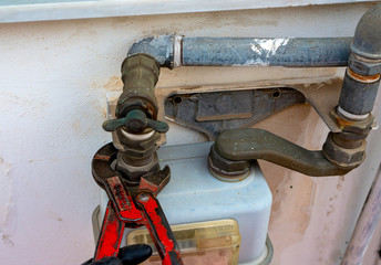 Worker with a caliper disassembles a fitting between the pipe and gas meter. Selective focus