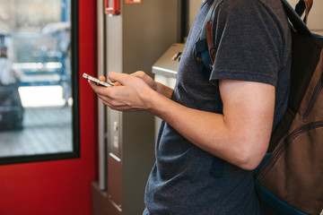 A tourist on the train uses a mobile phone to call or send a message or view a map or mobile application.