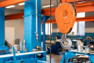Crane hook. The system of pulleys and ropes, a hanging mechanism in the production area. Movement remote control pendant switch for overhead crane in the factory
