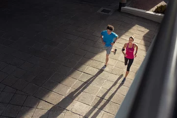 Foto op Plexiglas Joggen Ouder paar joggen bij zonsondergang