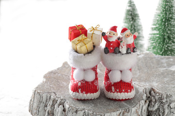 森の中の切り株と長靴の上のクリスマスプレゼントとサンタクロース