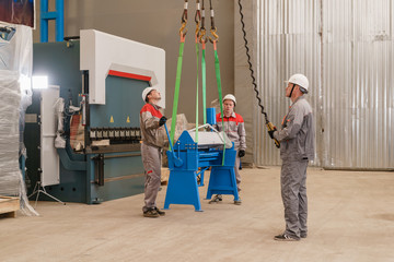 Production of ventilation and drainpipe. Workers adjusts the machine in the warehouse. the...