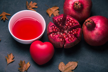 Pomegranate juice and pieces of pomegranate fruit on dark background