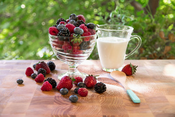 Fototapeta na wymiar healthy berry breakfast with milk on the window in the summer