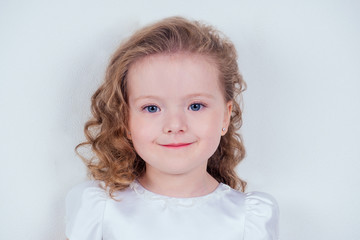 Naklejka premium Portrait of a lovely little girl curly blonde hairstyle