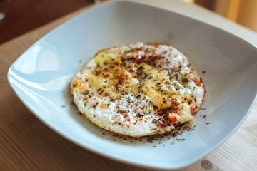 Fried eggs with cheese and spices