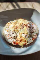 Fried eggs with cheese and spices