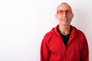 Studio shot of happy bald senior man smiling while wearing eyegl