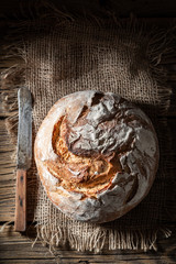 Tasty loaf of bread on dark and rustic table