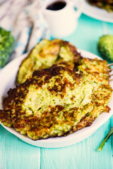 fried broccoli pancakes on a plate on a wooden board