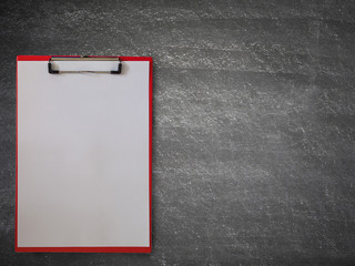 Blank paper on clipboard , on a blackboard.