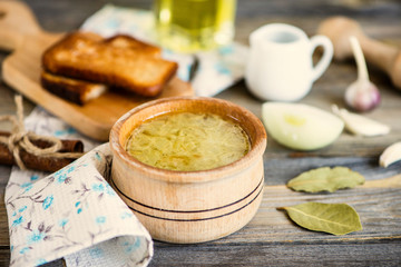 onion soup in a pot and croutons on a wooden board