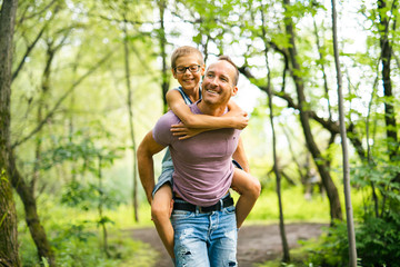 Father giving his son a piggyback ride, having fun