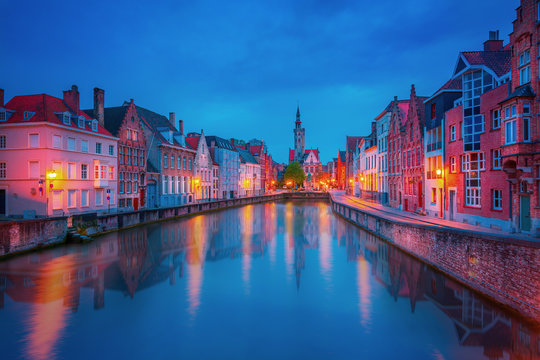 Scenic city view of Bruges canal with beautiful medieval colored houses, bridge and reflections in the evening, Belgium
