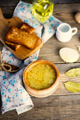 onion soup in a pot and croutons on a wooden board