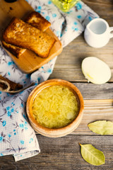 onion soup in a pot and croutons on a wooden board