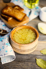 onion soup in a pot and croutons on a wooden board