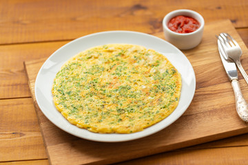 Delicious scrambled eggs with herbs. Omelet for Breakfast. Scrambled eggs with grated cheese and herbs. Egg dish for Breakfast.