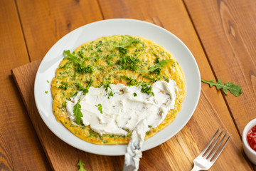 Delicious scrambled eggs with herbs. Omelet for Breakfast. Scrambled eggs with grated cheese and herbs. Egg dish for Breakfast.
