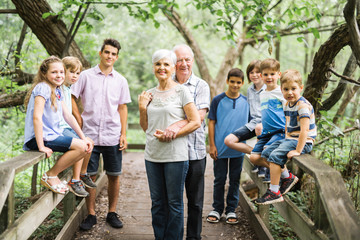 Fun time for family children and grandparent in summer forest