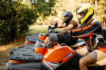 Two atv riders before the trip in summer forest