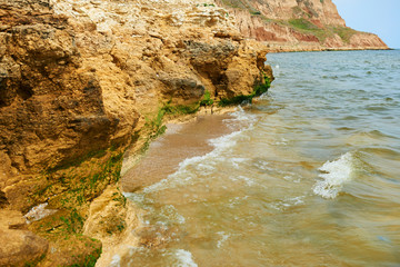beautiful sea landscape, closeup of stone on the beach, sea coast with high hills, wild nature