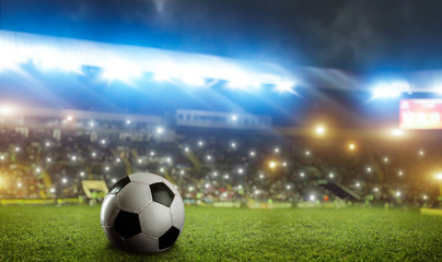 Football ball on green grass of the stadium field