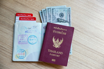 Thai passport, dollars banknote, airline ticket. time to travel and freedom concept.welcome to summer vacation seasons.business trip,trust to international immigration.