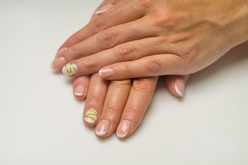 French manicure and nail gel Polish. The decoration of the nail white and gold decor. Top view Close-up photography