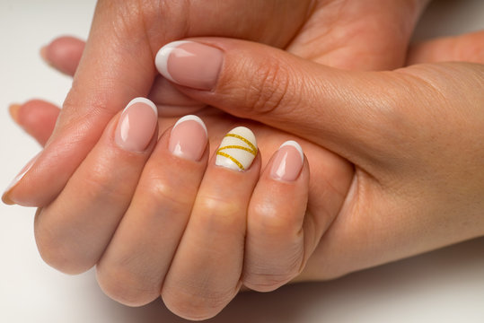 French Manicure And Nail Gel Polish. Young, Perfect, Groomed Woman's Hands With Pink And White Nail Varnish Bottles.